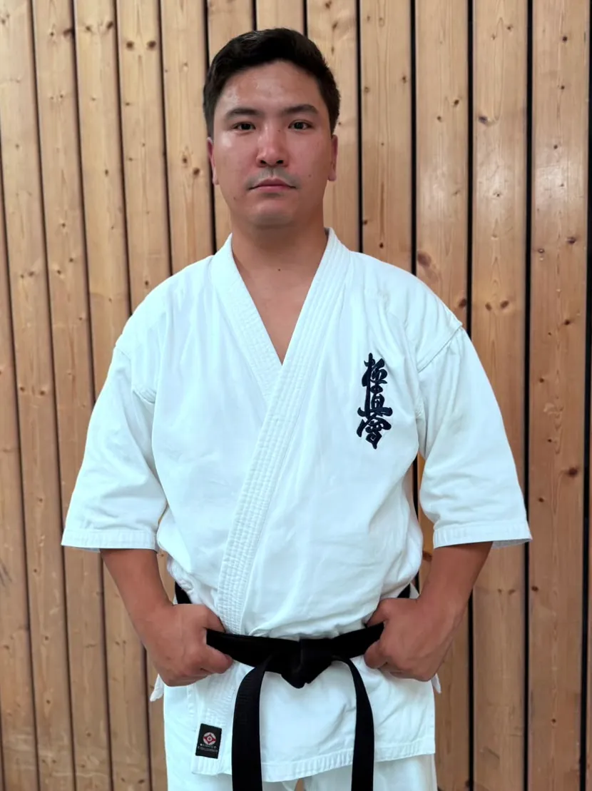Senpai Choi, 1. Dan Kyokushin Karate, Trainer der Kyokushinkai Karate Köpenick e.V., vor einer Holzwand
