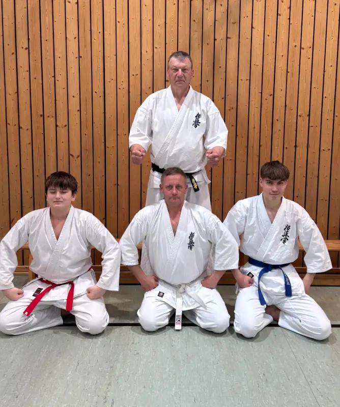 Erster Schultag mit Senpai Peter – 27.4.2026 Drei Karateka im weißen Kyokushin-Gi knien auf dem Hallenboden beim ersten Schultag bei Senpai Peter mit Wadim, Lukas und Mike.