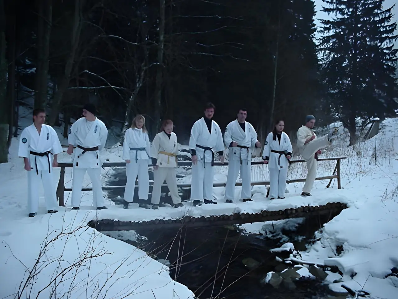 KKK e.V. Gruppe auf winterlicher Holzbrücke Gruppe von Karateka des Kyokushinkai Karate Köpenick e.V. im Gi steht im Winter auf einer verschneiten Holzbrücke über einem Bach auf dem Weg zum Training