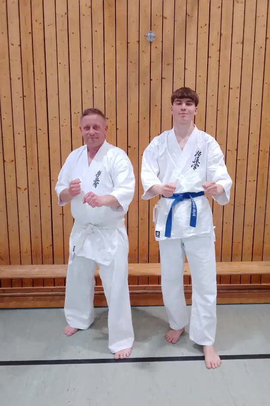 Lukas und Mike beim Karate-Training 2026 Lukas und Mike im weißen Karate-Gi beim Kyokushin-Training in einer Sporthalle.