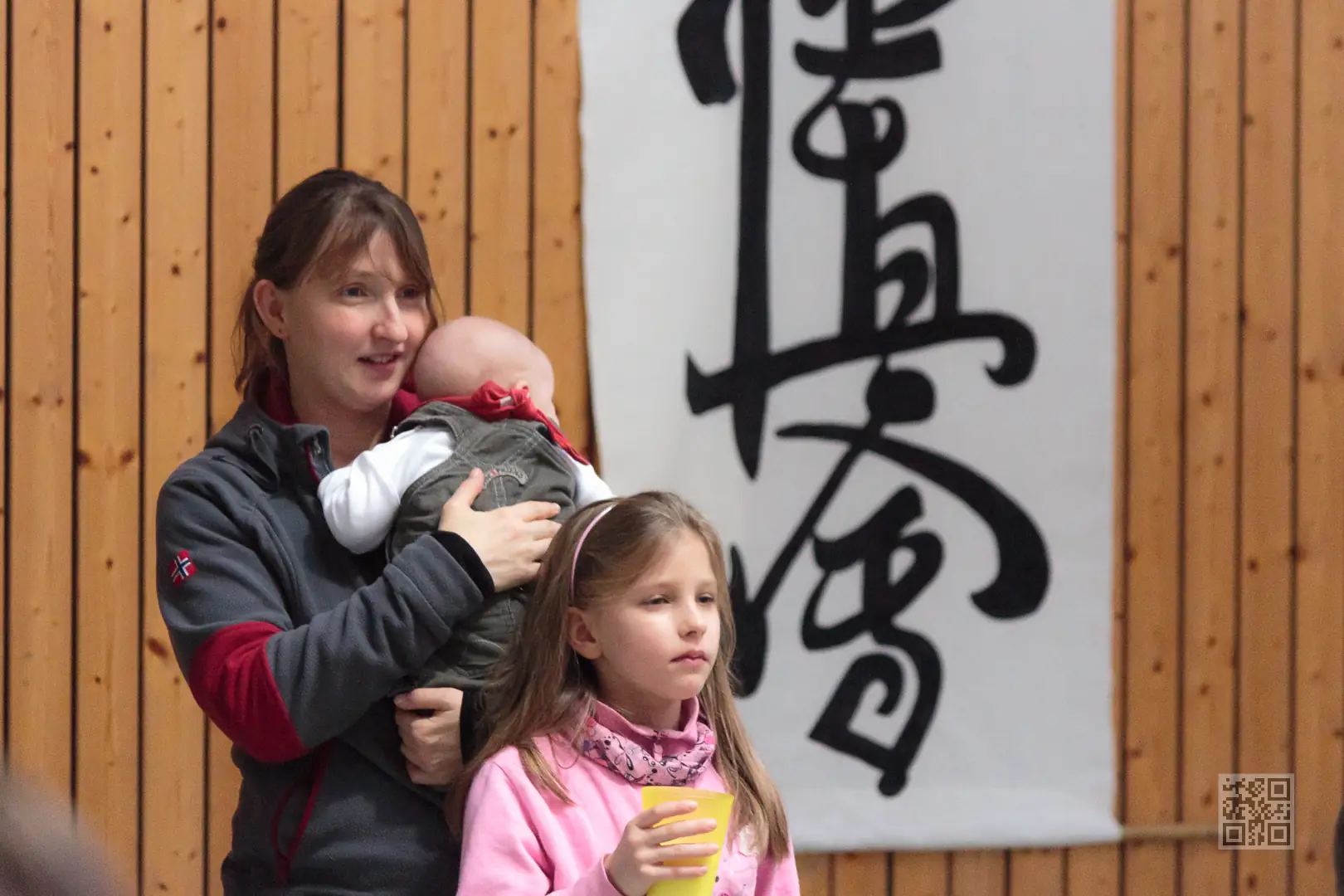 Begeisterte Zuschauer beim Karateturnier Mutter mit Baby und Kind schauen begeistert einem Karateturnier des Kyokushinkai Karate Köpenick e.V. zu